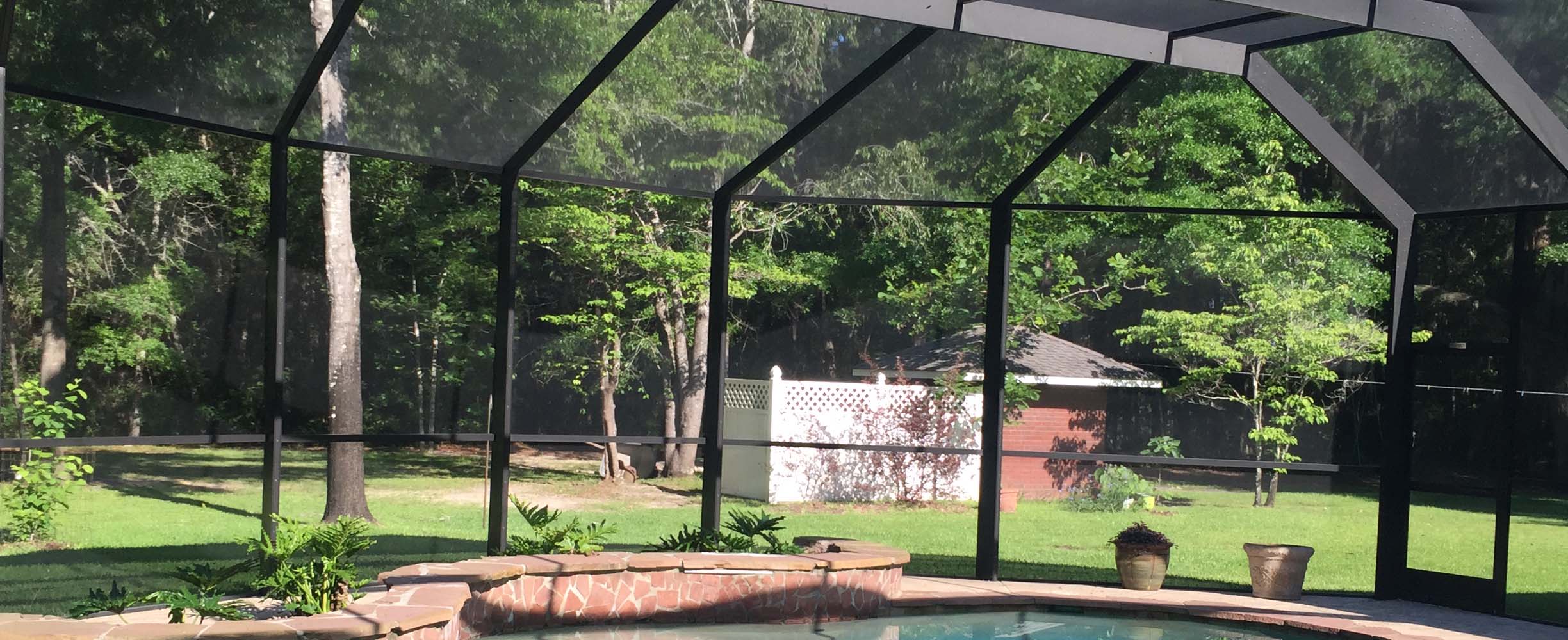 Pool enclosure with black aluninum and modern materials and structure that stands typical Southern high winds and weather