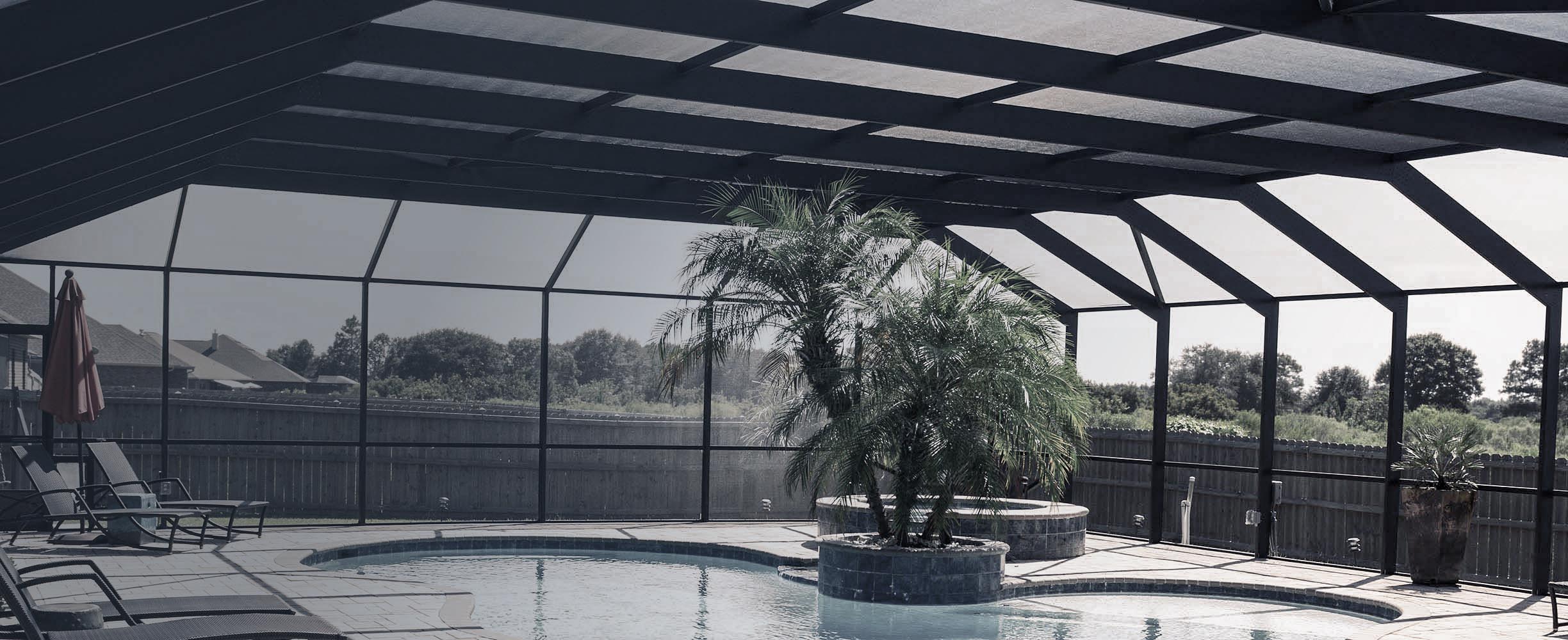 Custom aluminum pool enclosure surrounding a backyard pool in Baldwin County, Alabama