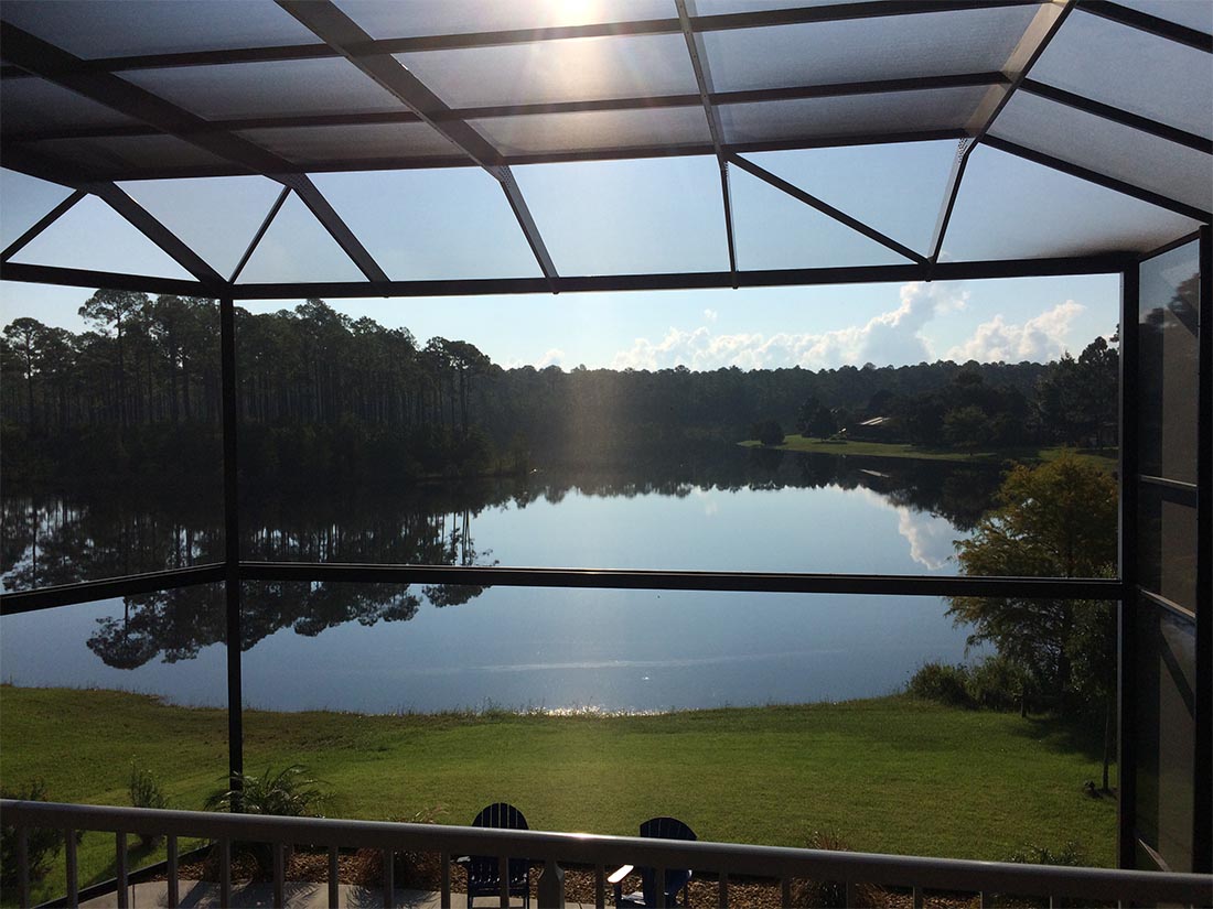Wide picture-window opening of a MegaView pool enclosure overlooking a South Alabama lake