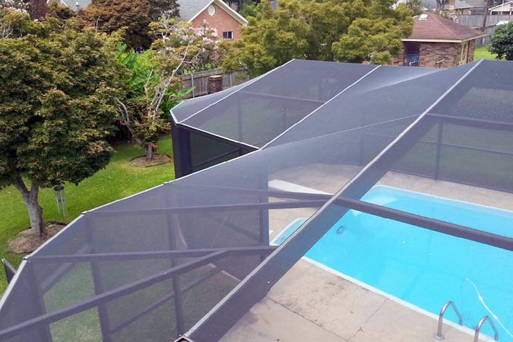 Large custom aluminum pool enclosure spanning a curved residential pool
