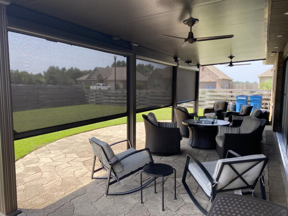 Motorized retractable rolling screens lowered around a covered patio in Daphne, Alabama