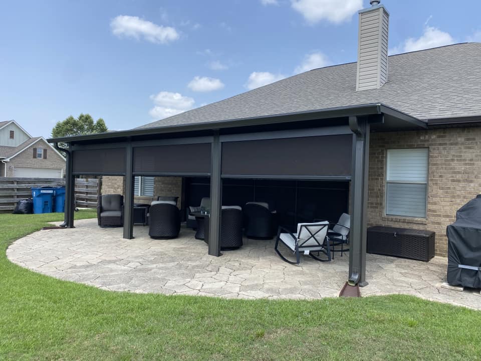 Exterior view of three retractable rolling screens partially raised on a Fairhope patio