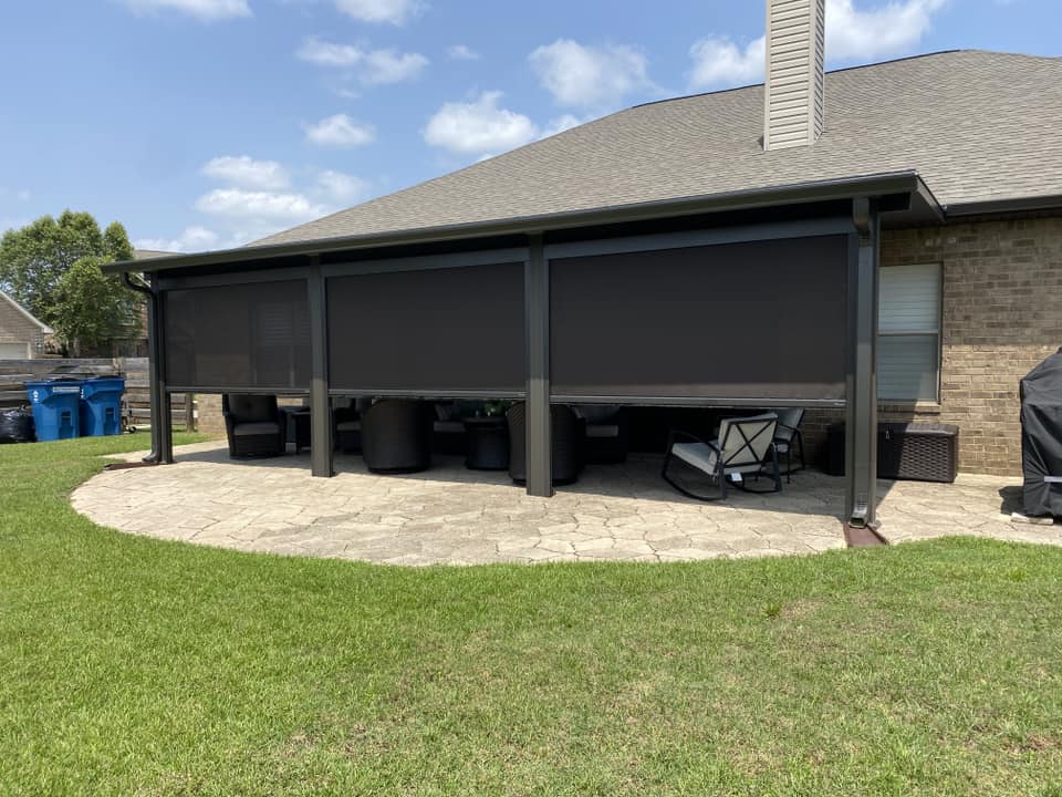 Three motorized roll-down screens lowered across a Spanish Fort patio